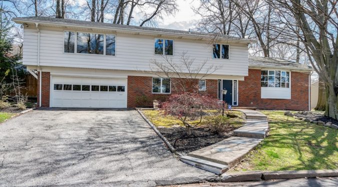 A house with a driveway and garage in front of it.