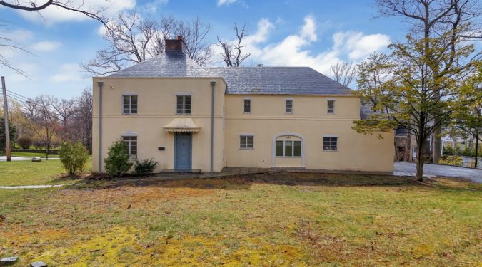 A large white house with blue door and windows.