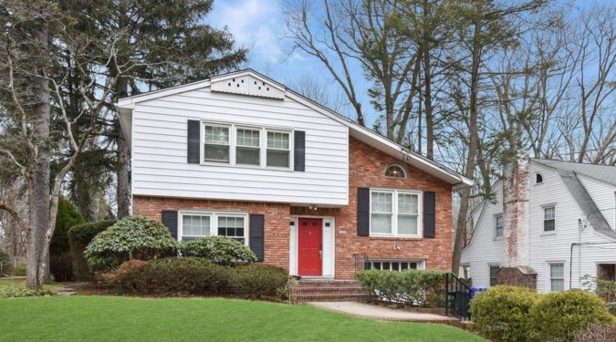 A brick house with red door and white trim.